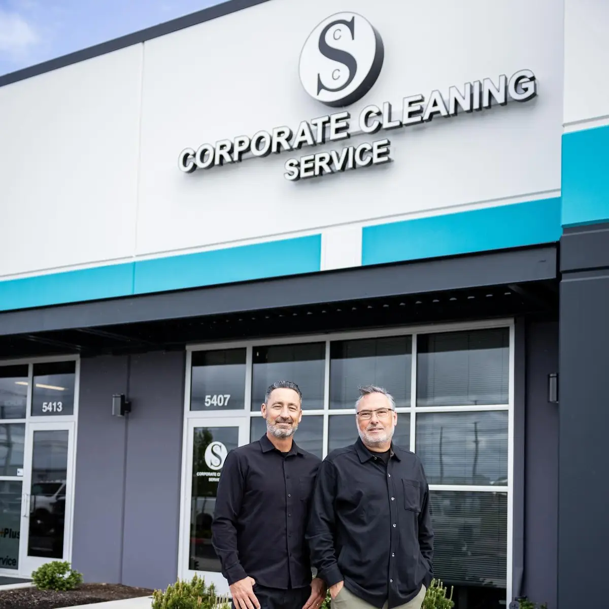 Two Corporate Cleaning leaders outside the company storefront