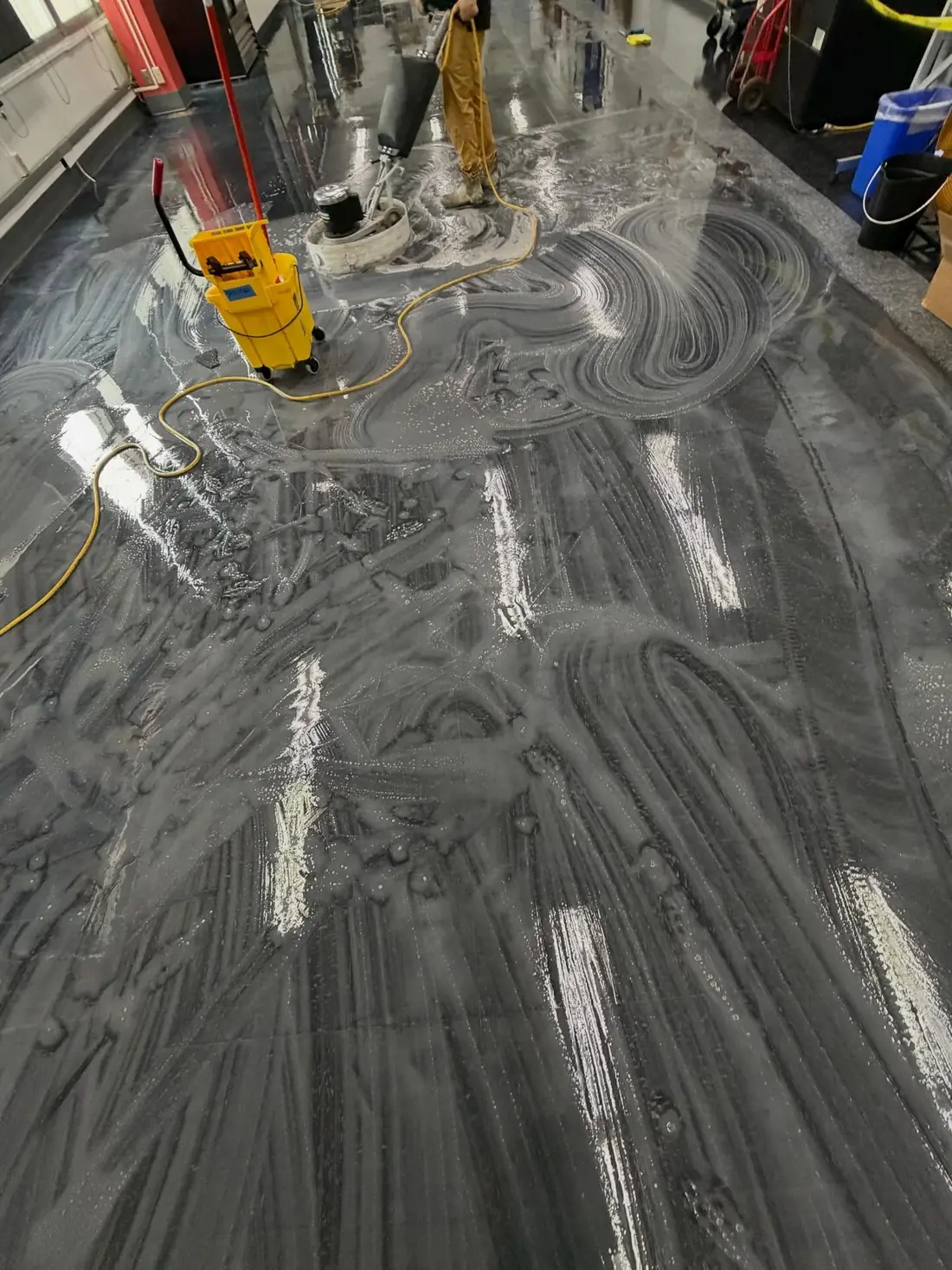 Floor scrubber and wet vacuum stripping a commercial hard floor