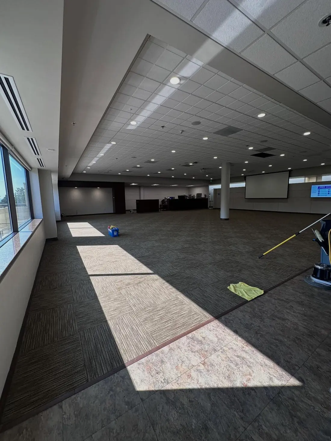 Corporate Cleaning crew member vacuuming a large open office floor